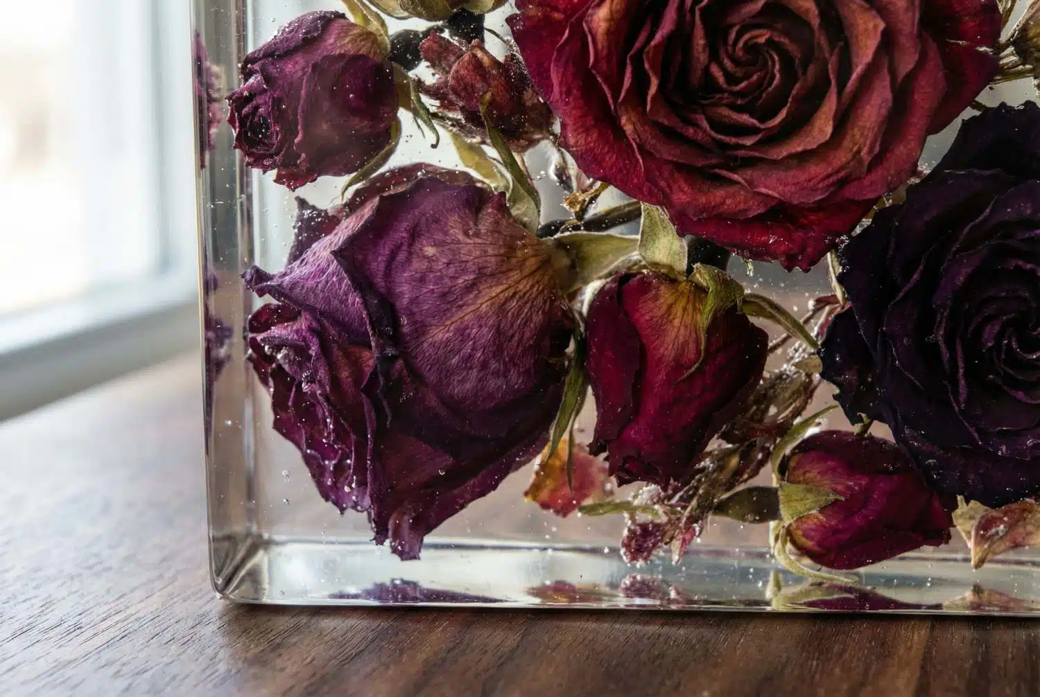 Close-up van transparante epoxy met ingegoten gedroogde rozen op houten ondergrond